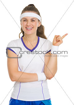 Happy tennis player pointing on copy space