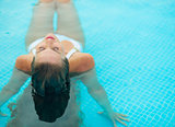 Young woman relaxing in pool. rear view
