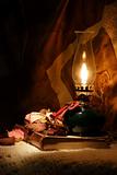 Oil lamp and an old book
