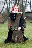 Gothic girl with a rose on a cemetery