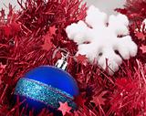 Christmas ball and snowflake on red tinsel