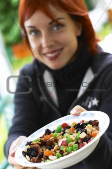 young laughing red-haired woman offering candied fruits