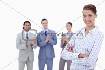 Close-up of a woman crossing her arms with business people appla