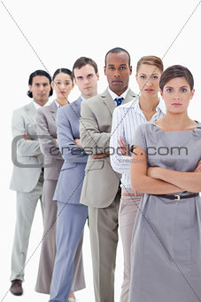 Close-up of a serious business team crossing their arms in a sin