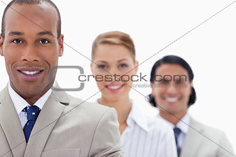 Big close-up of workmates in a single line smiling