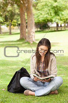 Teenager sitting while reading a textbook