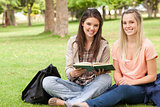 Female teenagers sitting with a textbook