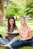 Two teenagers sitting with a textbook