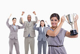 Woman holding up a cup with enthusiastic co-workers