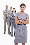 Woman smiling with her business team crossing their arms