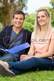 Portrait of a smiling tutor helping a teenager to revise 