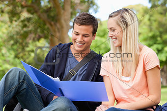 Close-up of a smiling tutor helping a teenager to revise 