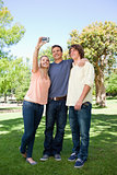 Three smiling students taking a pictures of themselves