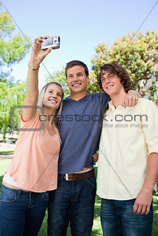 Three smiling friends taking a pictures of themselves