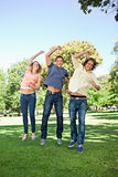 Three students jumping while raising an arm