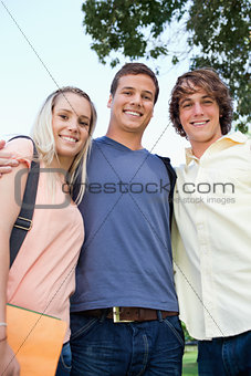 Low angle-shot of three friends shoulder to shoulder