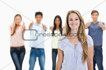 Close-up of woman smiling with people approving behind her