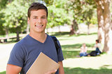 Portrait of a student smiling while holding a textbook