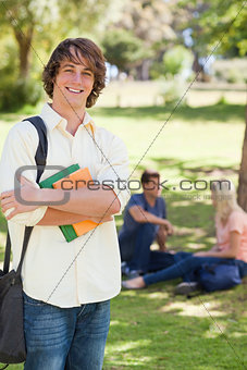 Smiling young man posing with textbook