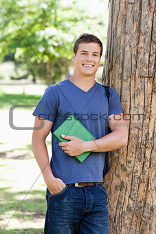 Portrait of a muscled student holding a textbook