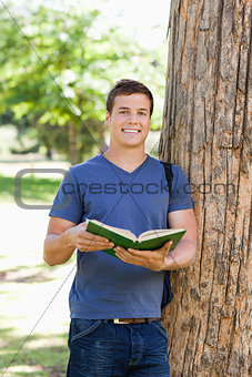 Portrait of a muscled young man holding a book