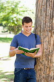 Muscled young man reading a book