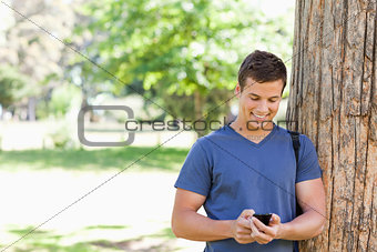 Muscled student using a smartphone