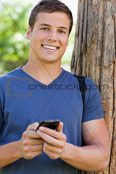 Portrait of a muscled student with a smartphone