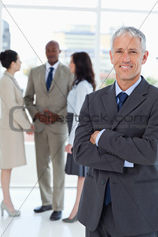 Mature smiling businessman crossing his arms in front of his col