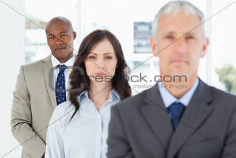 Young and serious businessman following two members of his team