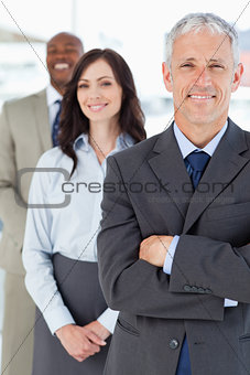 Mature manager in a suit followed by two young business people