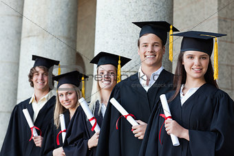 Portrait of graduates posing in single line