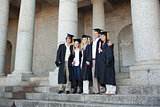 Five graduates posing while holding their diploma
