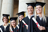 Close-up of five smiling graduates posing