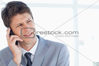 Stern businessman talking on the phone while looking towards the