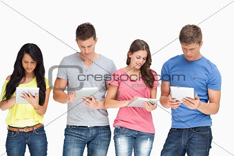 A group standing beside each other and using their tablet pc's