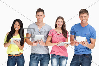 A group of people standing with their tablets in their hands