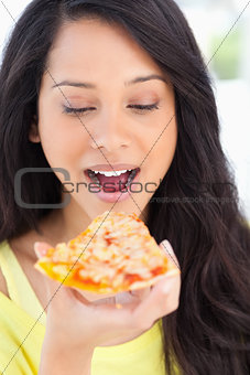 Close up of a woman looking at the slice of pizza she is about t