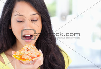 A woman about to eat a slice of pizza
