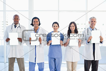 Medical team standing upright in front of the window while showi