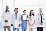 Medical team standing around an intern which is holding a blank 