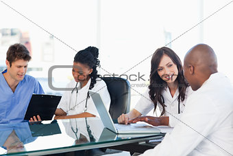 Medical team working on both a laptop and a clipboard