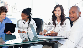 Two members of a medical team looking at the camera while workin