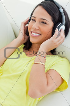 Close-up of a smiling Latino listening music on a smartphone