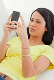 Close-up of a Latino frowning while looking her smartphone
