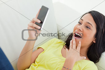 Close-up of a surprised Latino woman  looking her smartphone