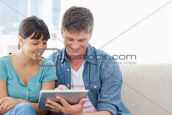 A couple sitting and using a tablet pc together 