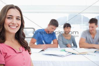 A close up of a woman looking into the camera with her friends b