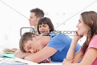 A sleeping student is being looked at by a confused fellow stude