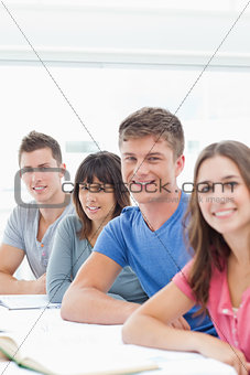 A group of young adults smiling as they all look at the camera